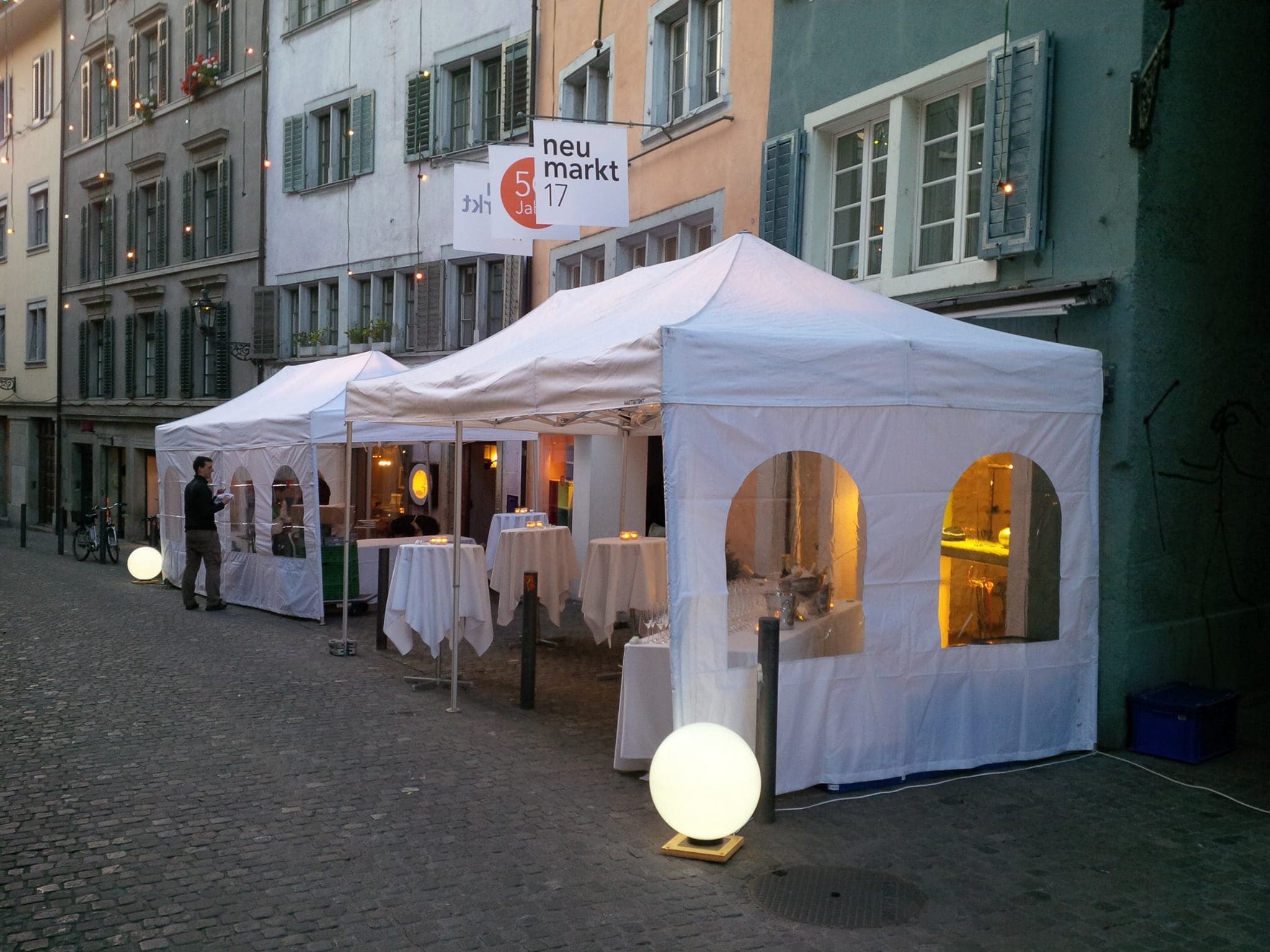 Weisse Faltpavillons am Abend in einer Altstadtgasse