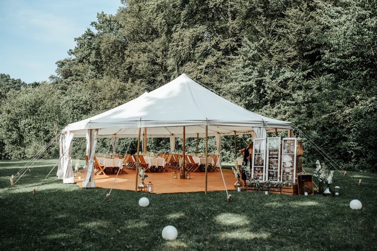 Stoffzelt im Garten mit Holzdeck und Kugelleuchten